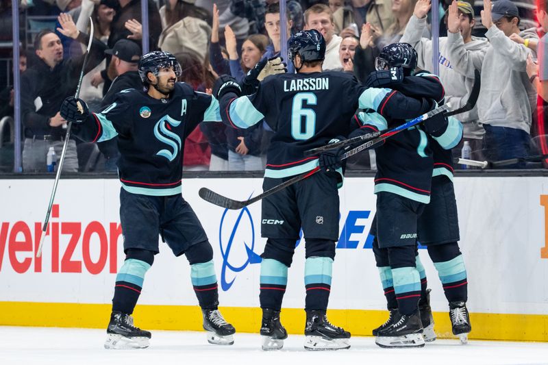 Oct 25, 2025; Seattle, Washington, USA; Seattle Kraken forward Matty Beniers (10), left, defenseman Adam Larsson (6) and forward Jordan Eberle (7) celebrate a goal during the third period against the Edmonton Oilers at Climate Pledge Arena. Mandatory Credit: Stephen Brashear-Imagn Images
