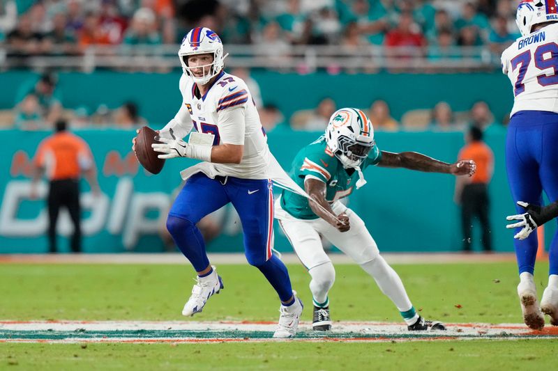 Miami Dolphins cornerback Jalen Ramsey (5) attempts to stop Buffalo Bills quarterback Josh Allen (17) during the first half of an NFL football game, Thursday, Sept. 12, 2024, in Miami Gardens, Fla. (AP Photo/Lynne Sladky)