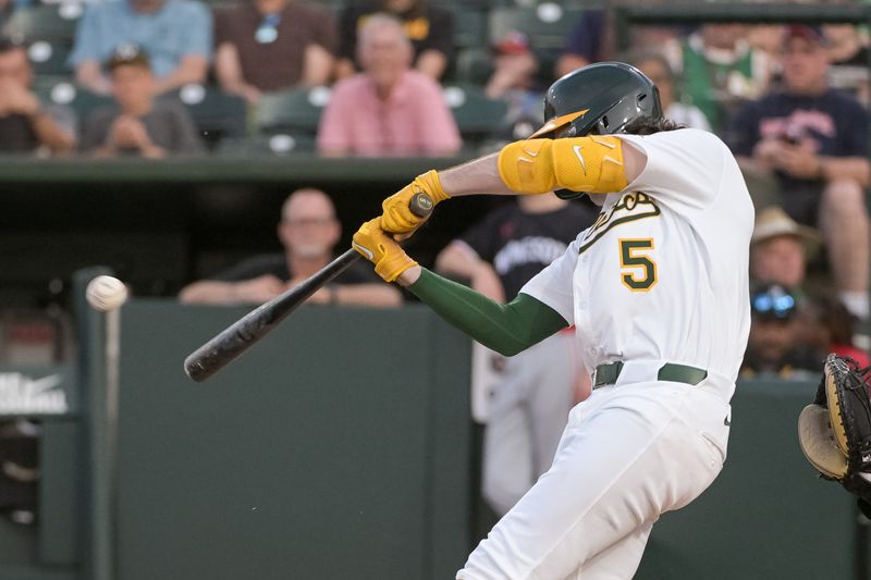 Jun 4, 2025; West Sacramento, California, USA; Athletics shortstop Jacob Wilson (5) hits a single against the Minnesota Twins during the third inning at Sutter Health Park. Mandatory Credit: Ed Szczepanski-Imagn Images