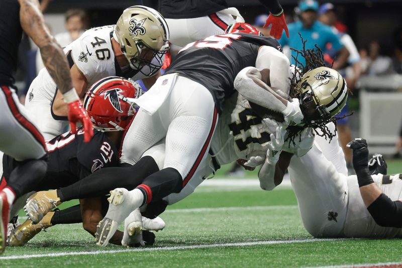 New Orleans Saints running back Alvin Kamara (41) scores a touchdown as Atlanta Falcons inside linebacker Kaden Elliss (55) attempts to tackle during the second half of an NFL football game, Sunday, Sept. 29, 2024, in Atlanta. (AP Photo/Stew Milne)