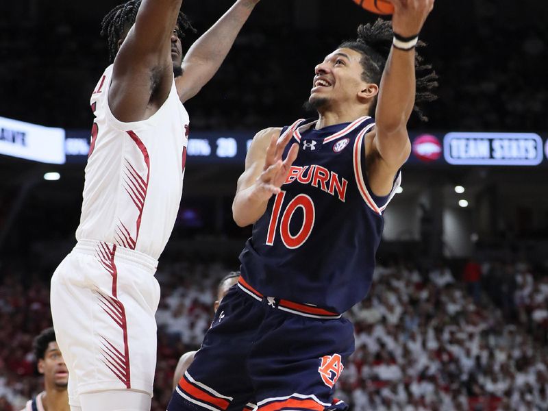 Jan 6, 2024; Fayetteville, Arkansas, USA; Auburn Tigers guard Denver jones (12) attempts a shot in the first half as Arkansas Razorbacks forward Makhi Mitchell (15) defends at Bud Walton Arena. Mandatory Credit: Nelson Chenault-USA TODAY Sports