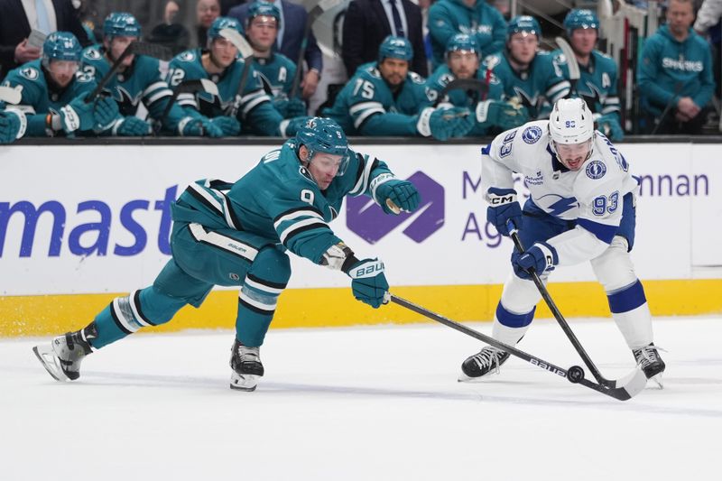 Jan 3, 2026; San Jose, California, USA; San Jose Sharks defenseman Dmitry Orlov (left) and Tampa Bay Lightning center Gage Goncalves (93) battle for the puck during the first period at SAP Center at San Jose. Mandatory Credit: Darren Yamashita-Imagn Images