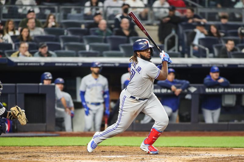 Apr 13, 2022; Bronx, New York, USA;  Toronto Blue Jays first baseman Vladimir Guerrero Jr. (27) hits a double in the sixth inning against the New York Yankees at Yankee Stadium. Mandatory Credit: Wendell Cruz-USA TODAY Sports