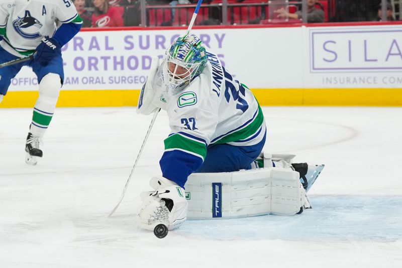 Nov 14, 2025; Raleigh, North Carolina, USA;  Vancouver Canucks goaltender Kevin Lankinen (32) makes a save against the Carolina Hurricanes during the first period at Lenovo Center. Mandatory Credit: James Guillory-Imagn Images