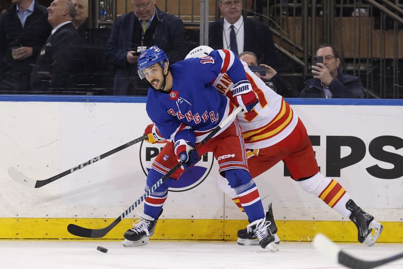 Feb 12, 2024; New York, New York, USA; New York Rangers center Vincent Trocheck (16) looks to pass the puck against Calgary Flames center Yegor Sharangovich (17) during the second period at Madison Square Garden. Mandatory Credit: Brad Penner-USA TODAY Sports