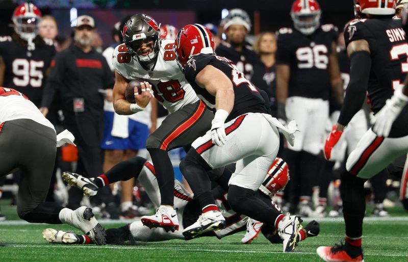 Tampa Bay Buccaneers tight end Cade Otton (88) carries the ball after a catch against the Atlanta Falcons during the first half of an NFL football game Thursday, Oct. 3, 2024, in Atlanta. (AP Photo/John Bazemore)