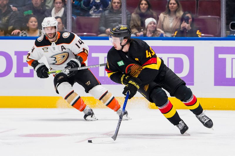 Nov 28, 2023; Vancouver, British Columbia, CAN; Anaheim Ducks forward Adam Henrique (14) watches as Vancouver Canucks defenseman Quinn Hughes (43) handles the puck   in the first period at Rogers Arena. Mandatory Credit: Bob Frid-USA TODAY Sports