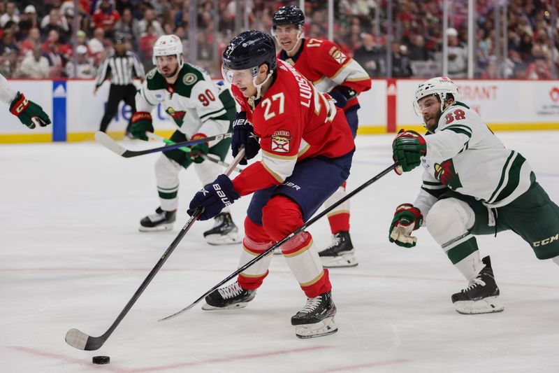 Jan 19, 2024; Sunrise, Florida, USA; Florida Panthers center Eetu Luostarinen (27) moves the puck past Minnesota Wild right wing Ryan Hartman (38) during the second period at Amerant Bank Arena. Mandatory Credit: Sam Navarro-USA TODAY Sports