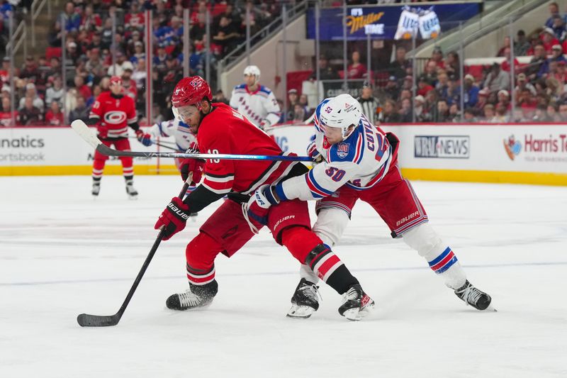 Dec 29, 2025; Raleigh, North Carolina, USA;  Carolina Hurricanes defenseman K'Andre Miller (19) tries the control the puck against New York Rangers left wing Will Cuylle (50) during the second period at Lenovo Center. Mandatory Credit: James Guillory-Imagn Images