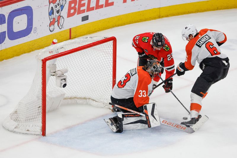 Feb 21, 2024; Chicago, Illinois, USA; Philadelphia Flyers goaltender Samuel Ersson (33) defends against Chicago Blackhawks center Philipp Kurashev (23) during the third period at United Center. Mandatory Credit: Kamil Krzaczynski-USA TODAY Sports