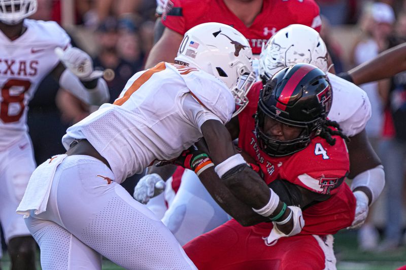 Sep 24, 2022; Lubbock, Texas, USA; Texas Tech Red Raiders runningback SaRodorick Thompson (4) is tackled by Texas Longhorns players during a game at Jones AT&T Stadium. Mandatory Credit: Aaron E. Martinez/Austin American-Statesman via USA TODAY NETWORK