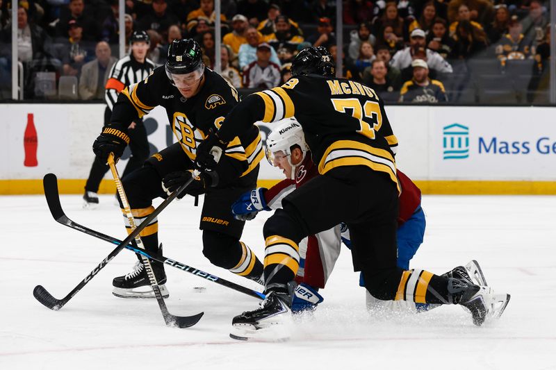 Oct 25, 2025; Boston, Massachusetts, USA; Colorado Avalanche center Nathan MacKinnon (29) gets caught between Boston Bruins defenseman Charlie McAvoy (73) and defenseman Nikita Zadorov (91) going for a loose puck during the first period at TD Garden. Mandatory Credit: Winslow Townson-Imagn Images
