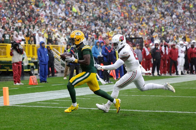 Green Bay Packers wide receiver Jayden Reed, defended by Arizona Cardinals linebacker Krys Barnes, catches a 5-yard pass for a touchdown during the first half of an NFL football game, Sunday, Oct. 13, 2024, in Green Bay. (AP Photo/Matt Ludtke)