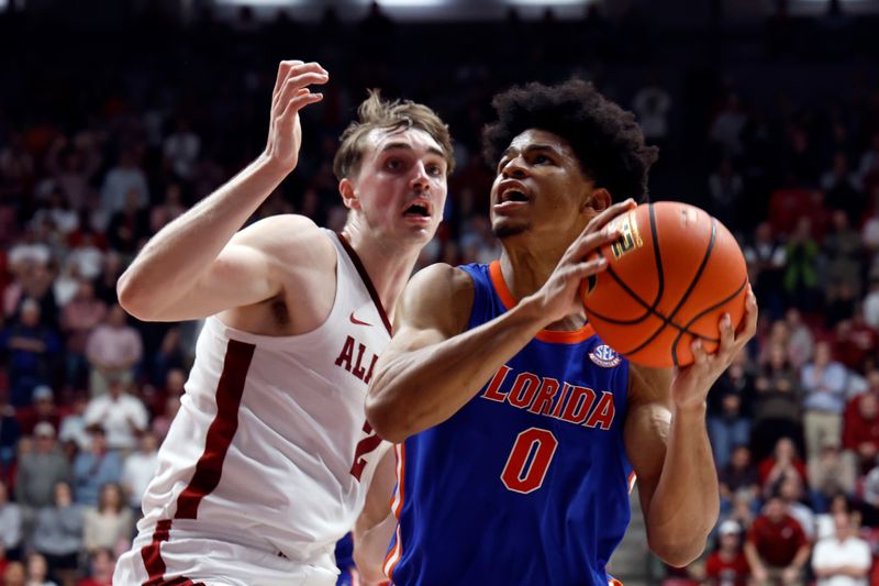 Feb 21, 2024; Tuscaloosa, Alabama, USA; Florida Gators guard Zyon Pullin (0) puts up a shot as Alabama Crimson Tide forward Grant Nelson (2) defends during the second half at Coleman Coliseum. Mandatory Credit: Butch Dill-USA TODAY Sports