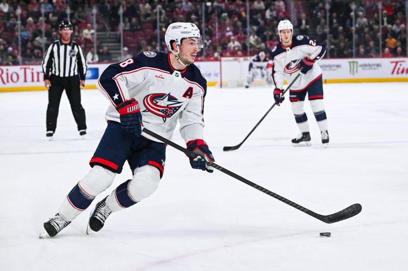 Mar 12, 2024; Montreal, Quebec, CAN; Columbus Blue Jackets defenseman Zach Werenski (8) plays the puck against the Montreal Canadiens during the second period at Bell Centre. Mandatory Credit: David Kirouac-USA TODAY Sports