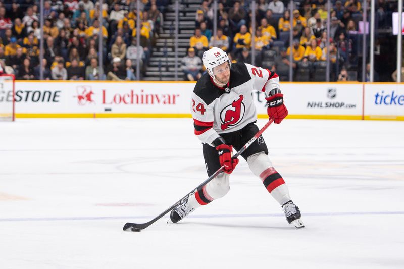 Feb 13, 2024; Nashville, Tennessee, USA;  New Jersey Devils defenseman Colin Miller (24) takes a shot on goal against the Nashville Predators during the second period at Bridgestone Arena. Mandatory Credit: Steve Roberts-USA TODAY Sports