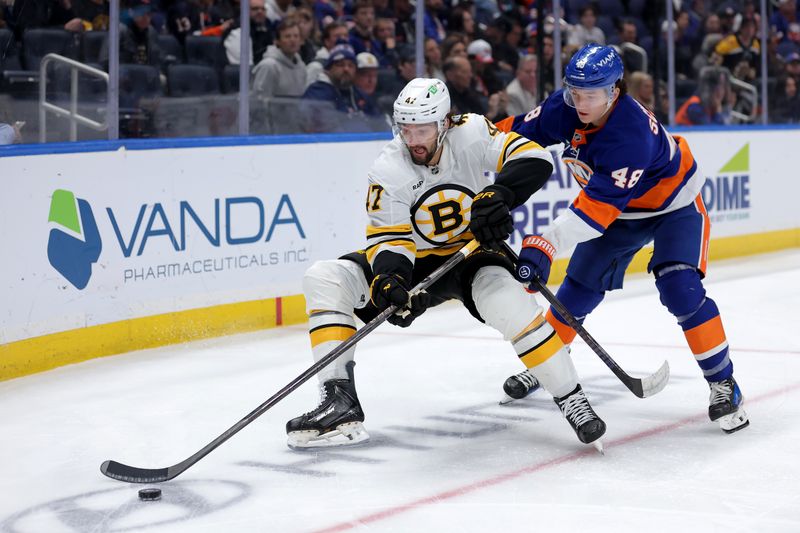 Nov 4, 2025; Elmont, New York, USA; New York Islanders defenseman Matthew Schaefer (48) cross checks Boston Bruins center Mark Kastelic (47) during the third period at UBS Arena. A penalty was called on Schaefer for the hit. Mandatory Credit: Brad Penner-Imagn Images