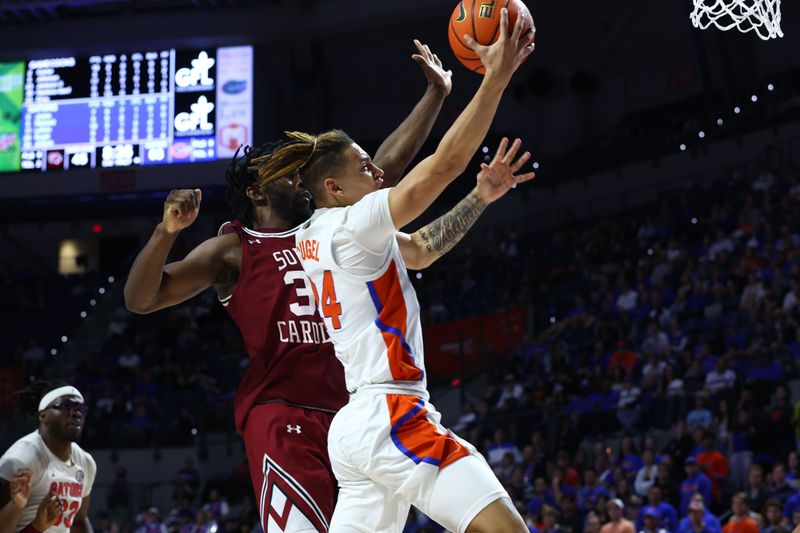 Jan 25, 2023; Gainesville, Florida, USA; Florida Gators guard Riley Kugel (24) shoots over South Carolina Gamecocks forward Josh Gray (33) during the second half at Exactech Arena at the Stephen C. O'Connell Center. Mandatory Credit: Kim Klement-USA TODAY Sports