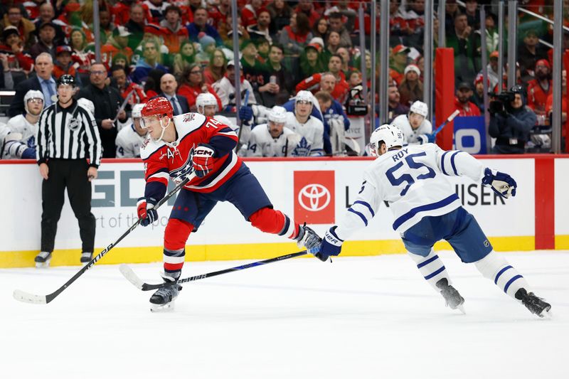 Nov 28, 2025; Washington, District of Columbia, USA; Washington Capitals defenseman John Carlson (74) shoots the puck as Toronto Maple Leafs center Nicolas Roy (55) defends during the third period at Capital One Arena. Mandatory Credit: Geoff Burke-Imagn Images