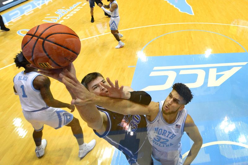 Mar 4, 2023; Chapel Hill, North Carolina, USA; Duke Blue Devils center Kyle Filipowski (30) shoots as North Carolina Tar Heels forward Pete Nance (32) defends in the first half at Dean E. Smith Center. Mandatory Credit: Bob Donnan-USA TODAY Sports