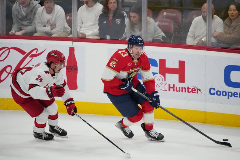 Nov 10, 2023; Sunrise, Florida, USA; Florida Panthers center Carter Verhaeghe (23) controls the puck away from Carolina Hurricanes center Seth Jarvis (24) during the first period at Amerant Bank Arena. Mandatory Credit: Jasen Vinlove-USA TODAY Sports