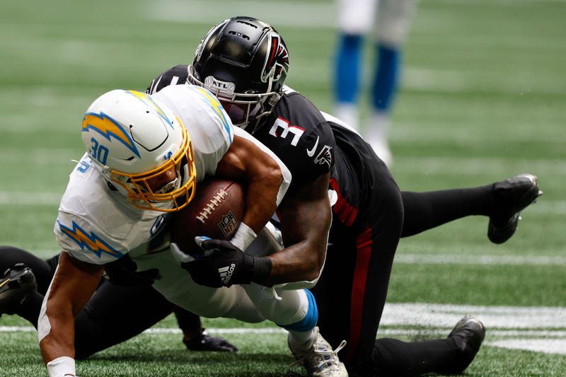 Los Angeles Chargers running back Austin Ekeler (30) is tackled by Atlanta Falcons linebacker Mykal Walker (3) during the first half of an NFL football game, Tuesday, Dec. 6, 2022, in Atlanta. (AP Photo/Butch Dill)