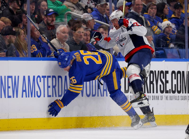 Apr 11, 2024; Buffalo, New York, USA;  Washington Capitals right wing T.J. Oshie (77) checks Buffalo Sabres defenseman Rasmus Dahlin (26) during the first period at KeyBank Center. Mandatory Credit: Timothy T. Ludwig-USA TODAY Sports