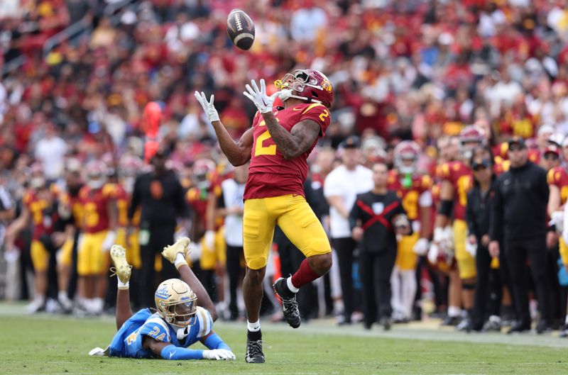 Nov 18, 2023; Los Angeles, California, USA; USC Trojans wide receiver Brenden Rice (2) catches a touchdown against UCLA Bruins defensive back Jaylin Davies (24) during the second quarter at United Airlines Field at Los Angeles Memorial Coliseum. Mandatory Credit: Jason Parkhurst-USA TODAY Sports