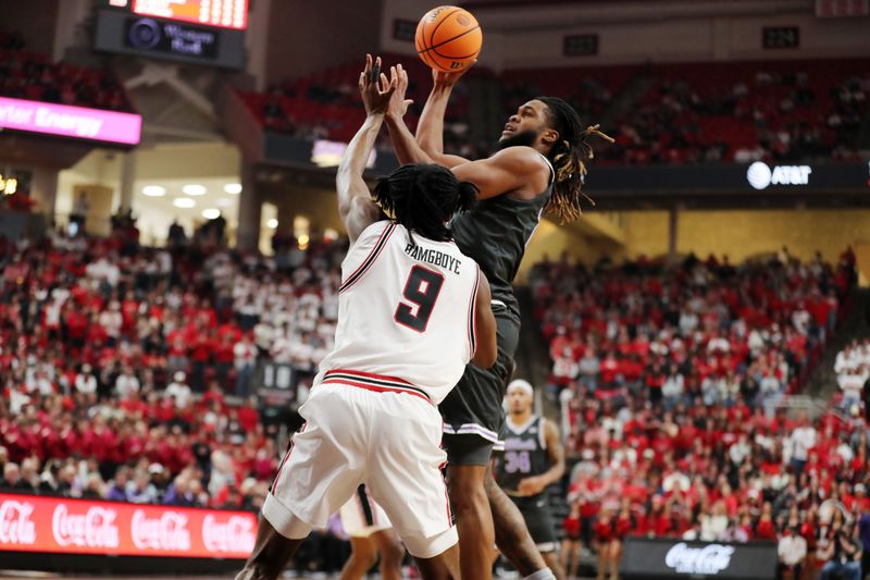 Feb 21, 2026; Lubbock, Texas, USA;  Kansas State Wildcats Khamari McGriff (21) shoots over Texas Tech Red Raiders forward Luke Bamgboye (9) in the first half at United Supermarkets Arena. Mandatory Credit: Michael C. Johnson-Imagn Images