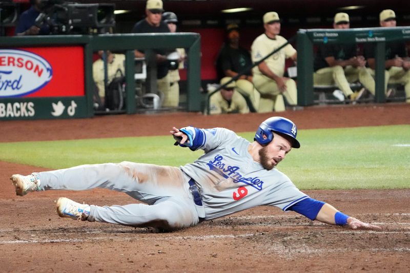 Aug 31, 2024; Phoenix, Arizona, USA; Los Angeles Dodgers second base Gavin Lux (9) slides at home to score a run against the Arizona Diamondbacks during the fifth inning at Chase Field. Mandatory Credit: Joe Camporeale-USA TODAY Sports