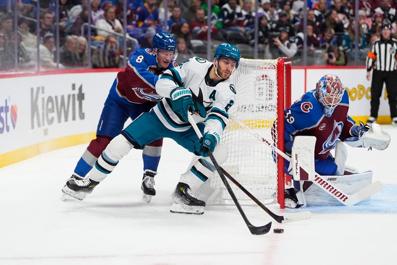 Nov 26, 2025; Denver, Colorado, USA; San Jose Sharks center Alexander Wennberg (21) wraps around the back of the net of Colorado Avalanche goaltender Mackenzie Blackwood (39) as defenseman Cale Makar (8) defends in the first period at Ball Arena. Mandatory Credit: Ron Chenoy-Imagn Images