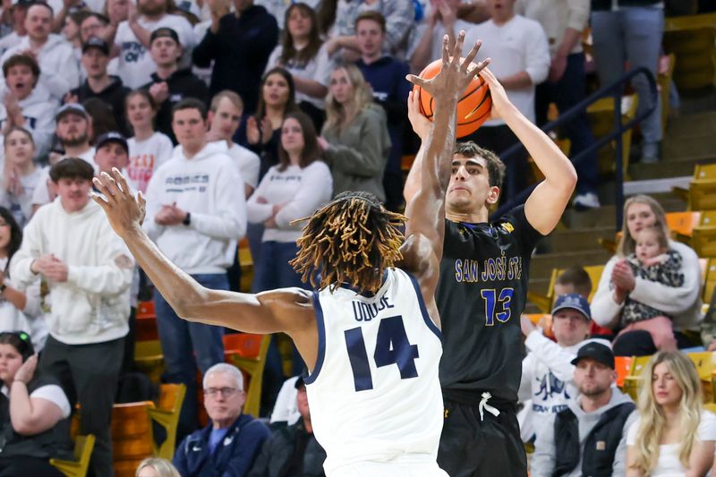 Jan 30, 2024; Logan, Utah, USA; San Jose State Spartans guard Alvaro Cardenas (13) shoots over Utah State Aggies guard Josh Uduje (14) during the first half at Dee Glen Smith Spectrum. Mandatory Credit: Rob Gray-USA TODAY Sports