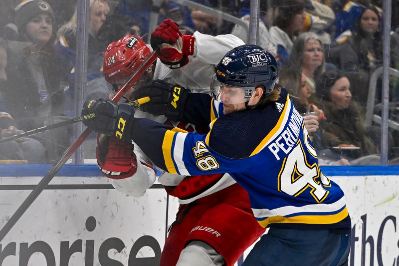 Apr 12, 2024; St. Louis, Missouri, USA;  St. Louis Blues defenseman Scott Perunovich (48) checks Carolina Hurricanes center Seth Jarvis (24) during the third period at Enterprise Center. Mandatory Credit: Jeff Curry-USA TODAY Sports