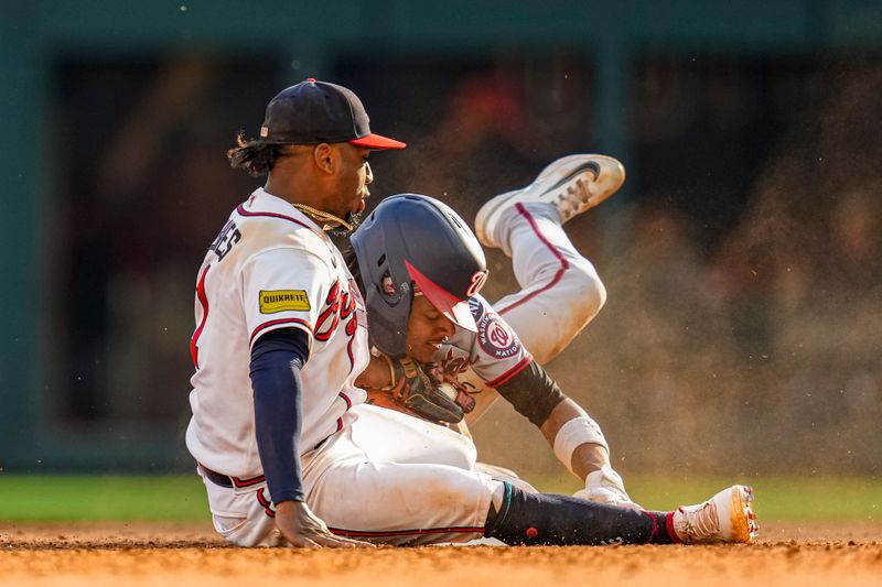 Oct 1, 2023; Cumberland, Georgia, USA; Washington Nationals shortstop CJ Abrams (5) collides with Atlanta Braves second baseman Ozzie Albies (1) after stealing second base during the eighth inning at Truist Park. Mandatory Credit: Dale Zanine-USA TODAY Sports