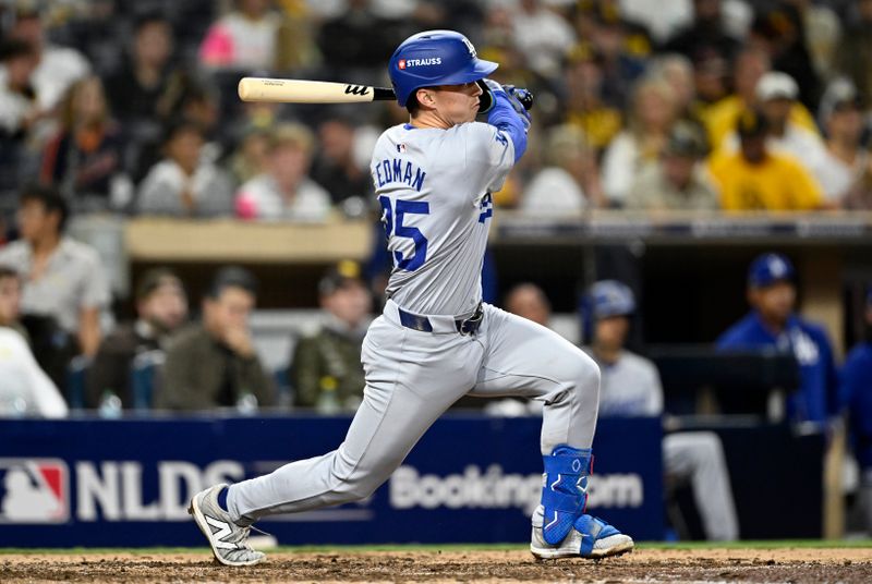 Oct 9, 2024; San Diego, California, USA; Los Angeles Dodgers outfielder Tommy Edman (25) singles in the ninth inning against the San Diego Padres during game four of the NLDS for the 2024 MLB Playoffs at Petco Park.  Mandatory Credit: Denis Poroy-Imagn Images