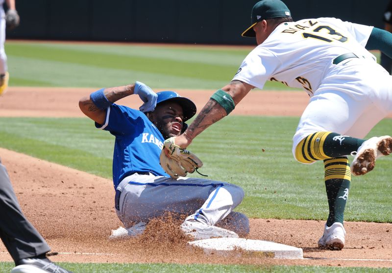 Aug 23, 2023; Oakland, California, USA; Oakland Athletics third baseman Jordan Diaz (13) catches Kansas City Royals third baseman Maikel Garcia (11) trying to steal third base during the third inning at Oakland-Alameda County Coliseum. Mandatory Credit: Kelley L Cox-USA TODAY Sports