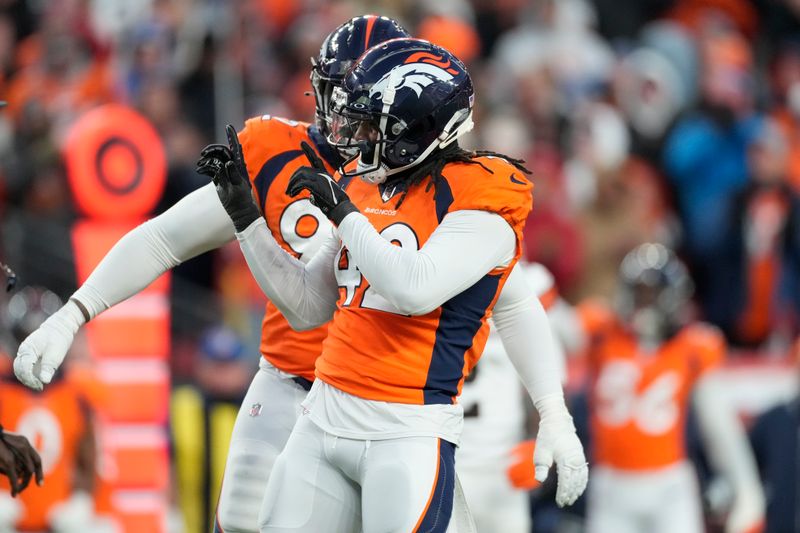 Denver Broncos linebacker Nik Bonitto, front, celebrates after sacking Cleveland Browns quarterback PJ Walker during the second half of an NFL football game on Sunday, Nov. 26, 2023, in Denver. (AP Photo/David Zalubowski)