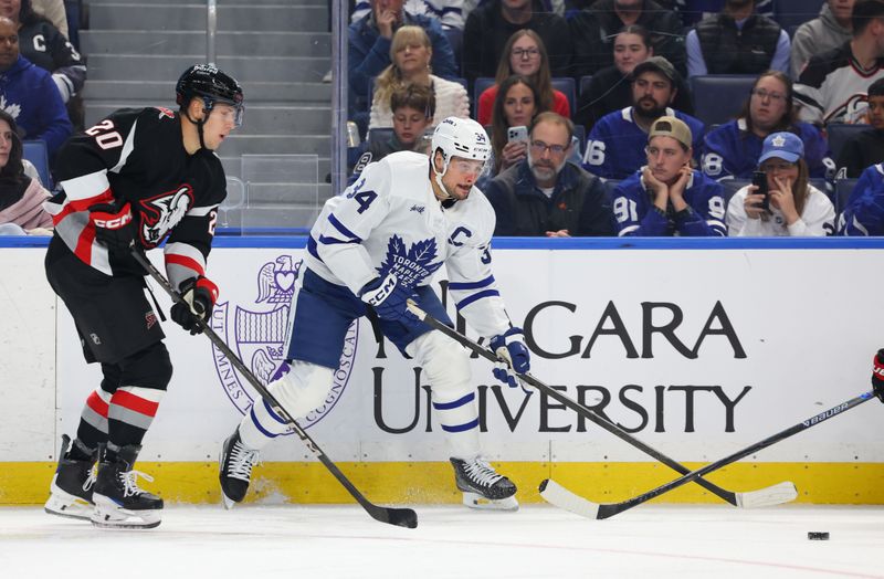Oct 24, 2025; Buffalo, New York, USA;  Buffalo Sabres center Jiri Kulich (20) watches as Toronto Maple Leafs center Auston Matthews (34) makes a pass during the third period at KeyBank Center. Mandatory Credit: Timothy T. Ludwig-Imagn Images