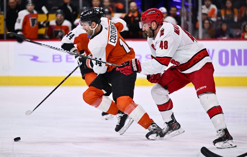 Nov 28, 2023; Philadelphia, Pennsylvania, USA; Carolina Hurricanes left wing Jordan Martinook (48) reaches against Philadelphia Flyers center Sean Couturier (14) in the first period at Wells Fargo Center. Mandatory Credit: Kyle Ross-USA TODAY Sports