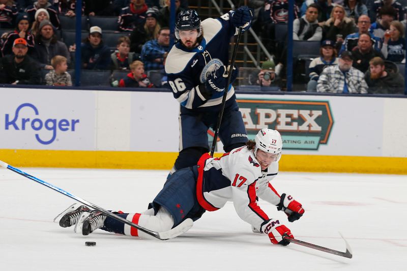 Dec 21, 2023; Columbus, Ohio, USA; Washington Capitals center Dylan Strome (17) loses control of the puck as Columbus Blue Jackets right wing Kirill Marchenko (86) defends during overtime at Nationwide Arena. Mandatory Credit: Russell LaBounty-USA TODAY Sports