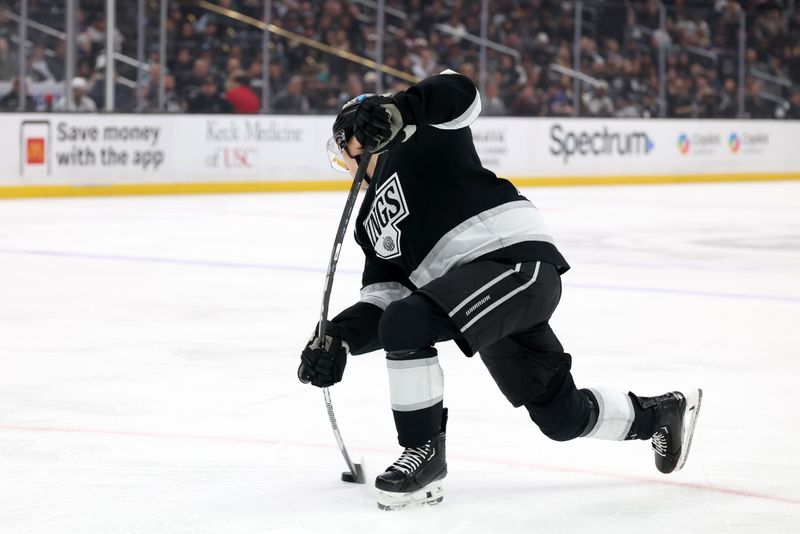Apr 7, 2025; Los Angeles, California, USA;  Los Angeles Kings defenseman Jordan Spence (21) shoots the puck during the second period against the Seattle Kraken at Crypto.com Arena. Mandatory Credit: Kiyoshi Mio-Imagn Images