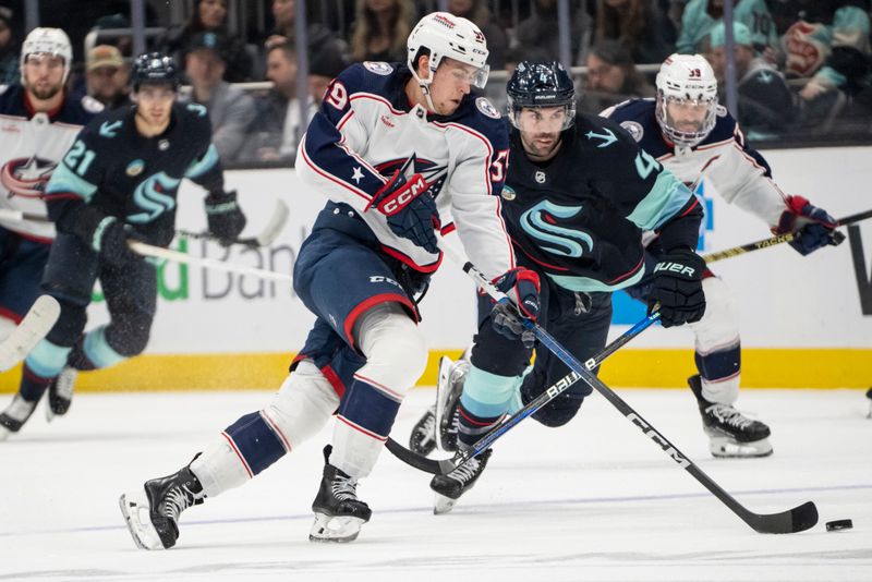 Jan 28, 2024; Seattle, Washington, USA; Columbus Blue Jackets forward Yegor Chinakhov (59) skates with the puck against Seattle Kraken defenseman Justin Schultz (4) during the third period at Climate Pledge Arena. Mandatory Credit: Stephen Brashear-USA TODAY Sports