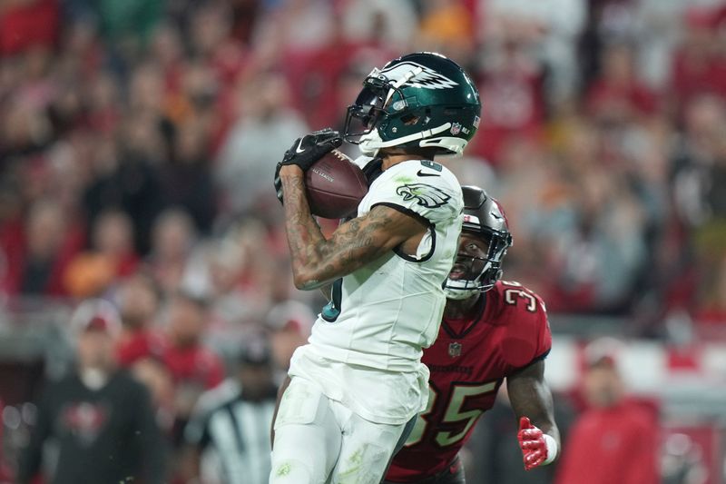 Philadelphia Eagles wide receiver DeVonta Smith (6) catches a deep pass as Tampa Bay Buccaneers cornerback Jamel Dean (35) defends during an NFL wild-card playoff football game, Monday, Jan. 15, 2024 in Tampa, Fla. (AP Photo/Peter Joneleit)