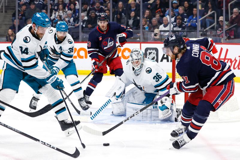 Feb 14, 2024; Winnipeg, Manitoba, CAN; Winnipeg Jets Kyle Connor (81) gets a rebound in front of San Jose Sharks goaltender Kaapo Kahkonen (36) in the second period at Canada Life Centre. Mandatory Credit: James Carey Lauder-USA TODAY Sports