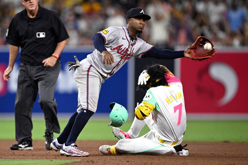 Jul 12, 2024; San Diego, California, USA; San Diego Padres shortstop Ha-Seong Kim (7) slides into second base ahead of the throw to Atlanta Braves second baseman Ozzie Albies (1) during the eighth inning at Petco Park. Mandatory Credit: Orlando Ramirez-USA TODAY Sports 