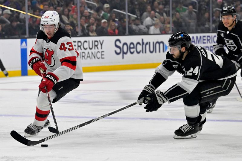 Mar 3, 2024; Los Angeles, California, USA;  New Jersey Devils defenseman Luke Hughes (43) and Los Angeles Kings center Phillip Danault (24) battle for the puck in the first period at Crypto.com Arena. Mandatory Credit: Jayne Kamin-Oncea-USA TODAY Sports