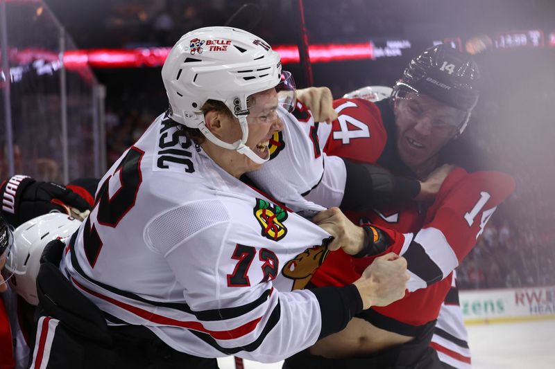 Jan 5, 2024; Newark, New Jersey, USA; Chicago Blackhawks defenseman Alex Vlasic (72) and New Jersey Devils right wing Nathan Bastian (14) fight during the second period at Prudential Center. Mandatory Credit: Ed Mulholland-USA TODAY Sports