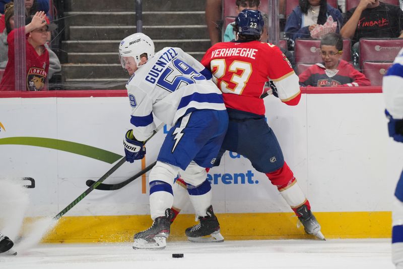 Sep 30, 2024; Sunrise, Florida, USA; Florida Panthers center Carter Verhaeghe (23) and Tampa Bay Lightning center Jake Guentzel (59) battle for possession during the second period at Amerant Bank Arena. Mandatory Credit: Jim Rassol-Imagn Images