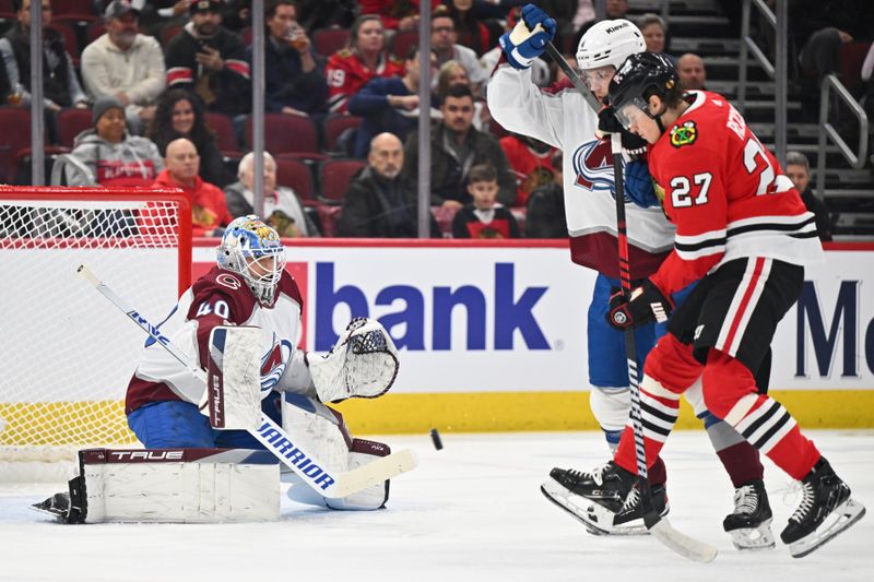 Dec 19, 2023; Chicago, Illinois, USA; Colorado Avalanche goaltender Alexandar Georgiev (40) makes a save as defenseman Bowen Byram (4) and Chicago Blackhawks forward Lukas Reichel (27) battle in front of the net during the first period at United Center. Mandatory Credit: Jamie Sabau-USA TODAY Sports