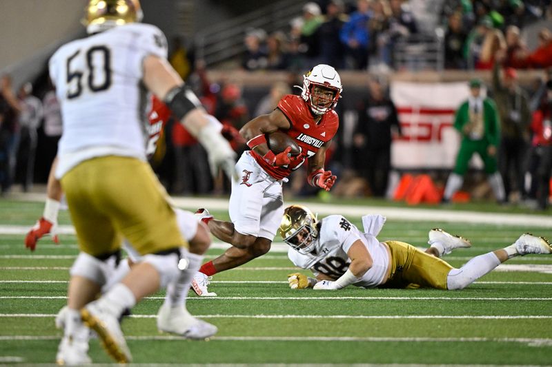 Oct 7, 2023; Louisville, Kentucky, USA; Louisville Cardinals defensive back Devin Neal (27) returns an interception past Notre Dame Fighting Irish tight end Mitchell Evans (88) during the second half at L&N Federal Credit Union Stadium. Louisville defeated Notre Dame 33-20. Mandatory Credit: Jamie Rhodes-USA TODAY Sports